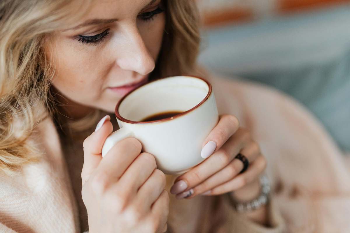 donna beve caffè tazza